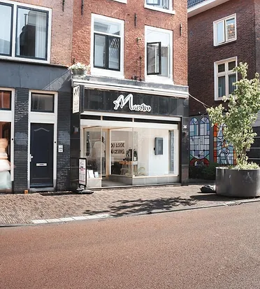 De gevel van Maestro aan de Wittevrouwenstraat, met de zwarte pui en het grote raam