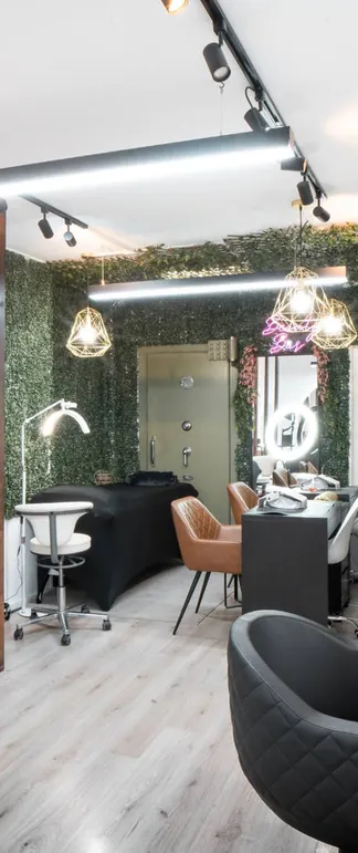 De beautybar met de groene haagwand en gouden hanglampen