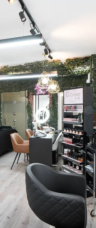 Gouden hanglampen boven de beautybar, voor de groene haagwand
